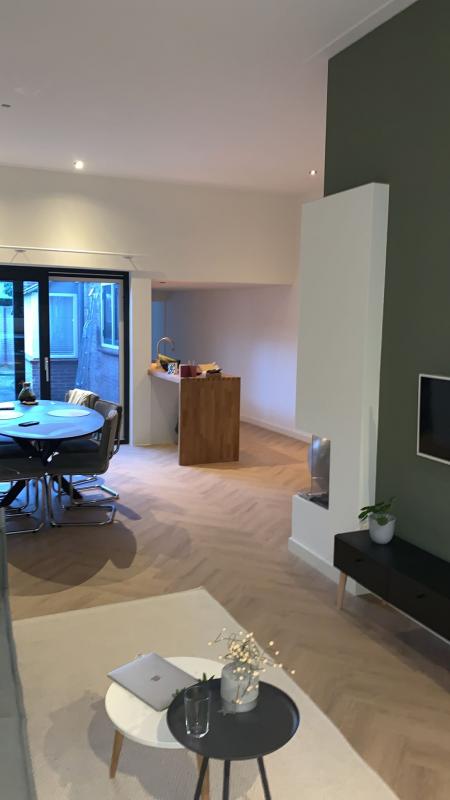 Afgewerkte open woonkamer met strakke witte wanden en plafond